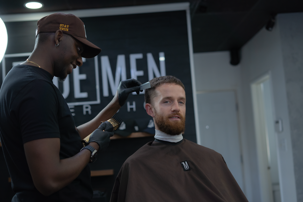 Caleb Sperling cutting a client's hair at the True Men barbershop
